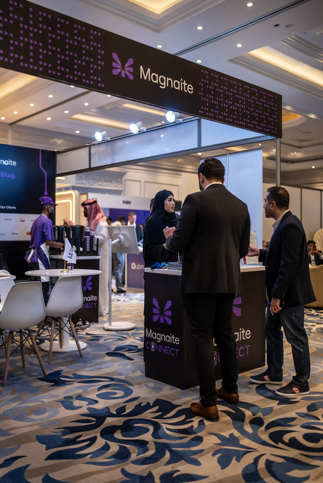 Visitors in conversation at the Magnaite Connect counter.