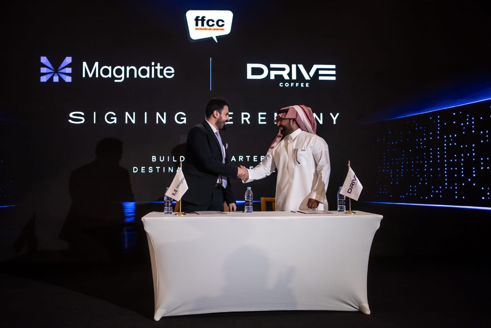 Handshake between Magnaite and Drive Coffee representatives following the signing.