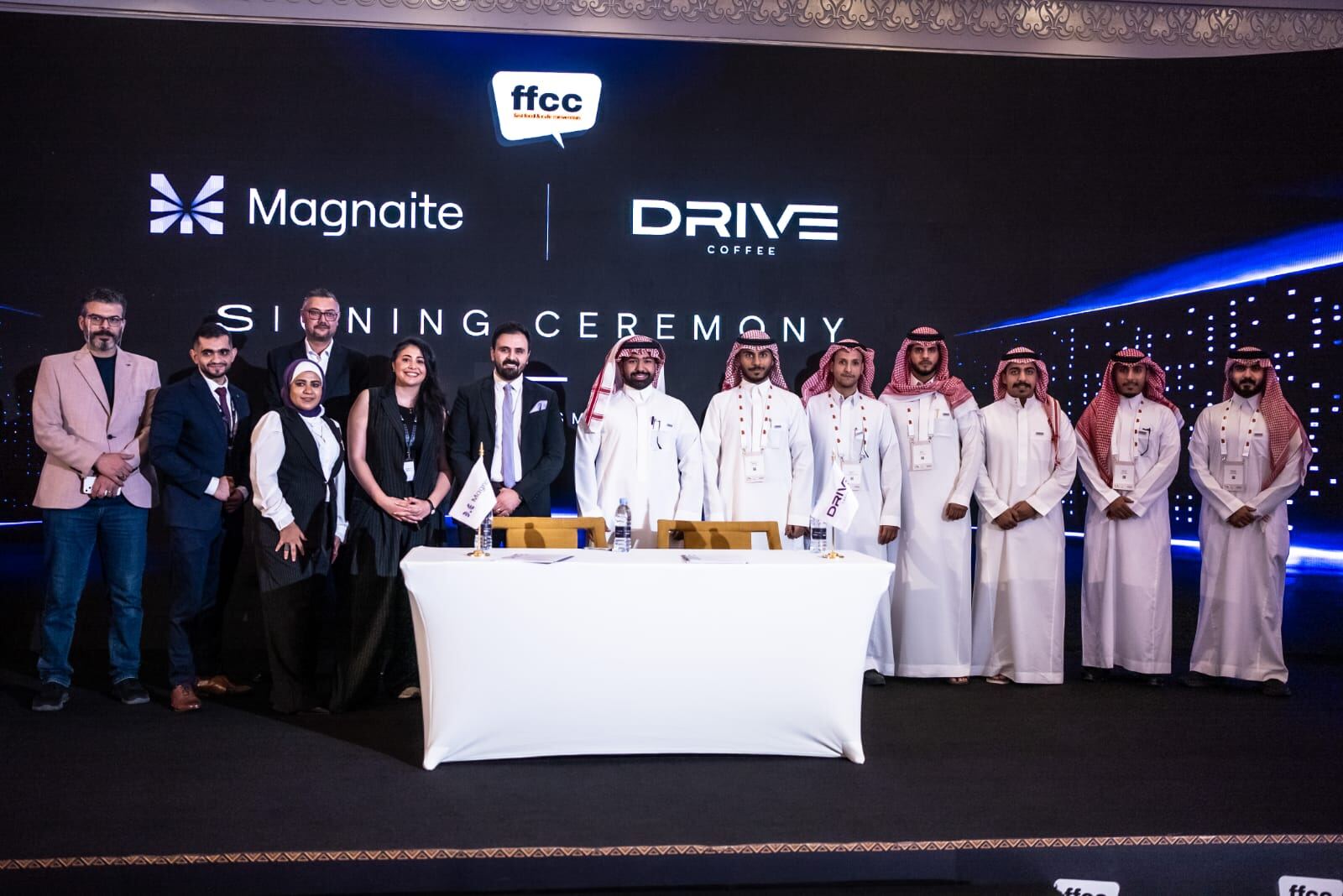 Full team photo on stage after the Magnaite × Drive Coffee signing ceremony.